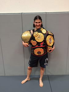 Roxanne Modafferi holding four MMA belts.